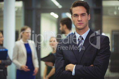 Businessman standing with arms crossed in the office