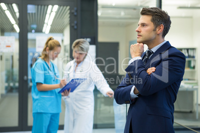 Thoughtful businessman standing in corridor