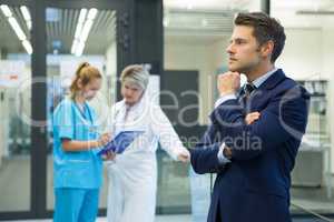 Thoughtful businessman standing in corridor