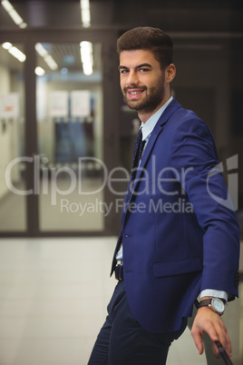 Portrait of handsome businessman standing in corridor