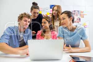 Executives discussing over laptop in office