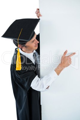 Male graduate student behind a panel and pointing with finger