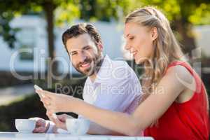 Couple using mobile phone in a restaurant