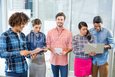 Executives using laptop, digital tablet and mobile phone