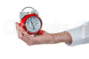 Hand of executive holding alarm clock