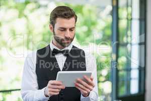 Male waiter using digital tablet