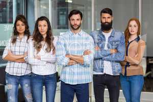 Portrait of male and female executives standing with arms crossed