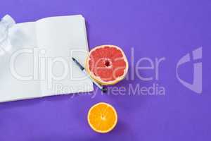 Grapefruit, lemon with opened book and pen