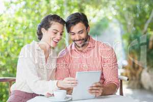 Couple smiling while using digital tablet
