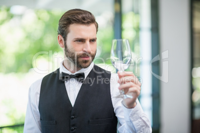 Male waiter holding wine glass in the restaurant