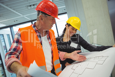 Businesswoman discussing over blueprint with a architect