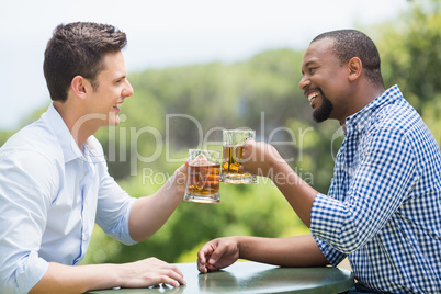 Happy friends toasting beer glasses