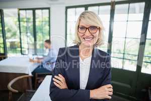 Businesswoman standing with arms crossed in a restaurant