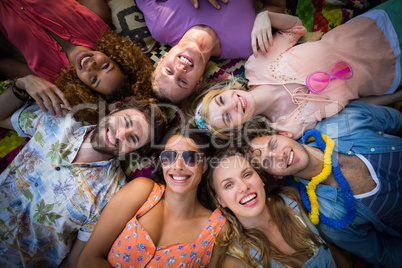 Group of friends lying in a circle at campsite