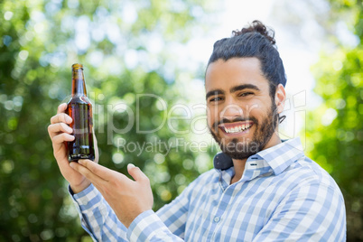 Man holding beer bottle in the park