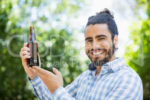 Man holding beer bottle in the park