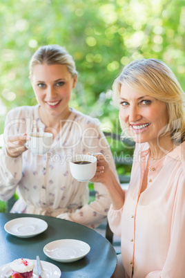 Smiling friends enjoying coffee together