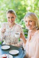 Smiling friends enjoying coffee together