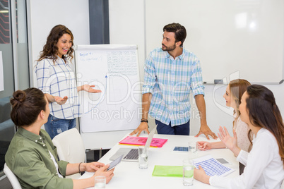 Team of executives having discussion over flip chart