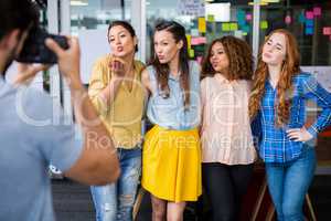 Man photographing his female colleagues with camera