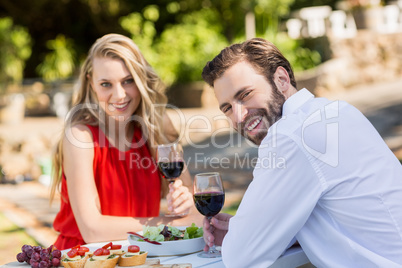 Happy couple holding wine glasses in the restaurant