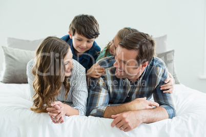 Family playing on bed in bedroom at home