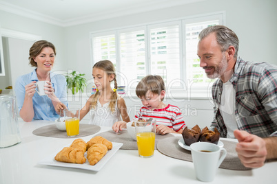 Smiling family having breakfast in the kitchen