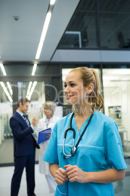 Thoughtful female doctor standing n corridor