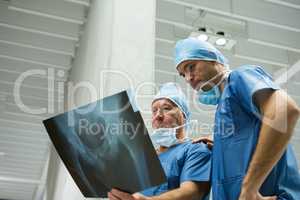 Male surgeons examining x-ray