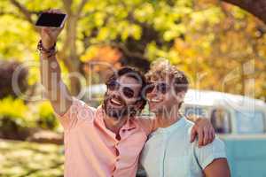 Two male friends taking selfie with mobile phone