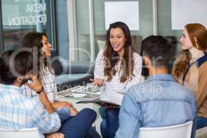 Male and female executives interacting with each other during meeting