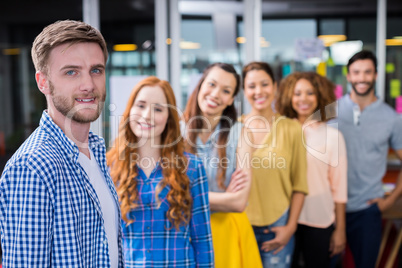 Portrait of male executive standing in front of colleagues