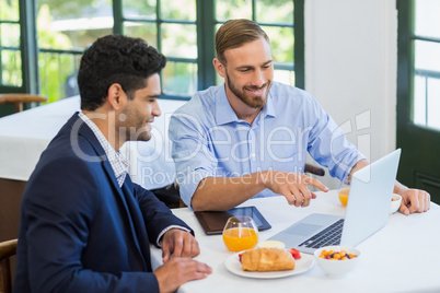 Businessman and colleague using laptop Businessman and colleague using laptop