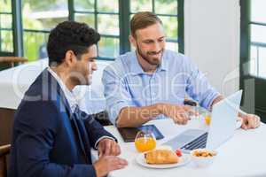 Businessman and colleague using laptop