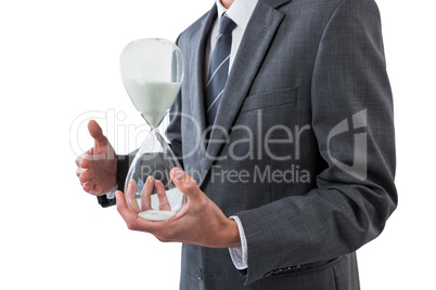 Mid section of businessman holding hourglass
