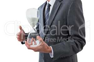 Mid section of businessman holding hourglass