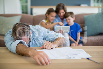 Worried man calculating bills in living room