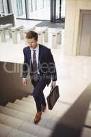 Businessman with briefcase climbing stairs