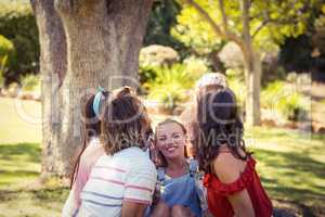 Group of friends lifting woman at campsite