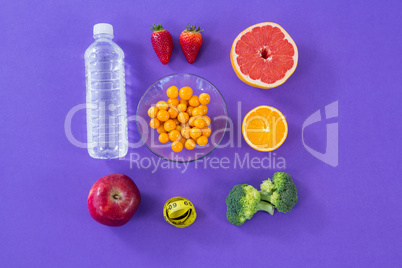 Water bottle, measuring tape, various fruits, vegetable and diet breakfast