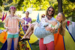 Man lifting woman at campsite