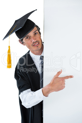 Male graduate student behind a panel and pointing with finger