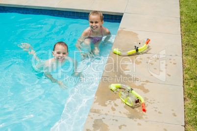 Smiling boy and girl playing in swimming pool