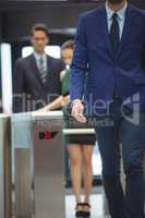 Businessman passing through turnstile gate at office