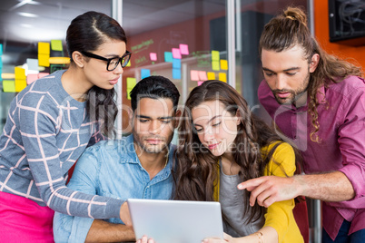 Graphic designers discussing over digital tablet