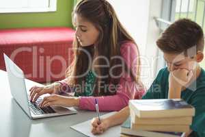 School kids doing homework in library