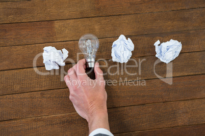 Businessman arranging light bulb with crumbled paper