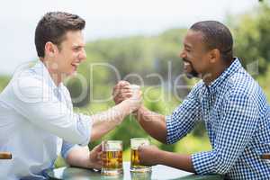 Friends greeting each other while holding beer glasses