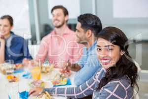 Portrait of happy female executive having breakfast