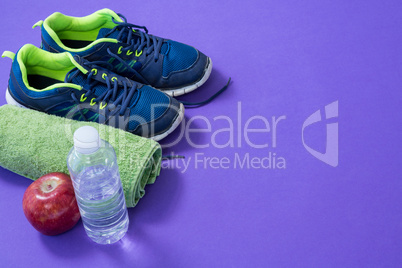 Water bottle, towel, apple and sneakers